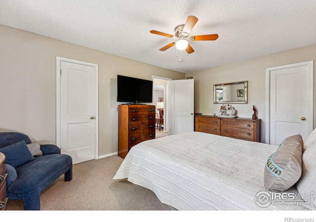 carpeted bedroom featuring ceiling fan and a textured ceiling