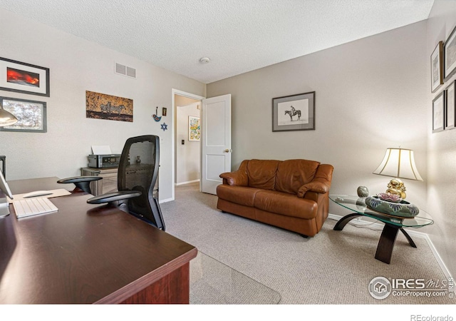 carpeted office featuring baseboards, a textured ceiling, and visible vents