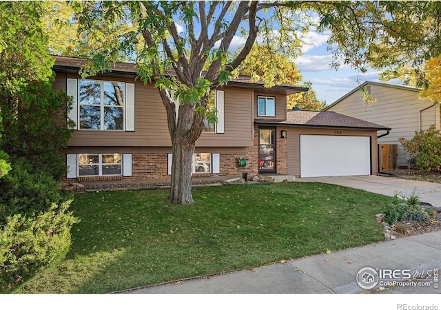 view of front of property featuring brick siding, an attached garage, driveway, and a front lawn