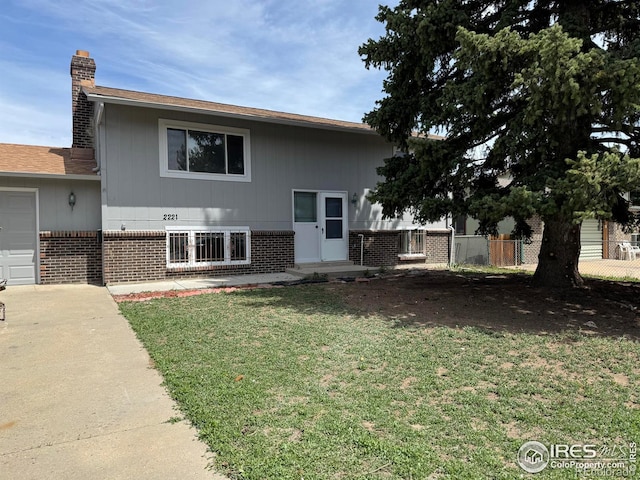 2221 E 84th Ave, Denver, CO 80229 - view of front of home featuring brick siding, a chimney, a garage, and driveway