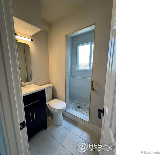 2221 E 84th Ave, Denver, CO 80229 - bathroom with toilet, a shower stall, vanity, and tile patterned floors