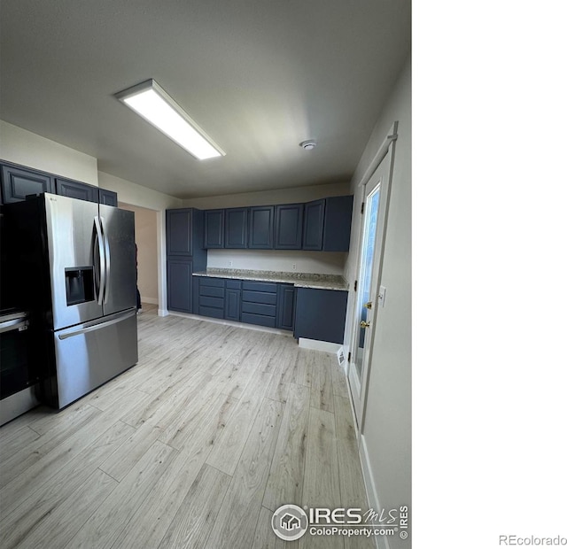 2221 E 84th Ave, Denver, CO 80229 - kitchen with stainless steel fridge, light wood-style flooring, light countertops, baseboards, and blue cabinetry