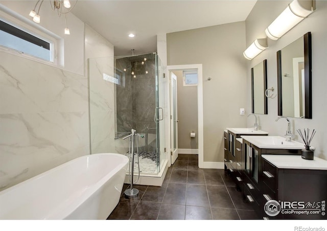 2624 S Race St, Denver, CO 80210 - full bathroom featuring a stall shower, a soaking tub, double vanity, tile patterned floors, and baseboards