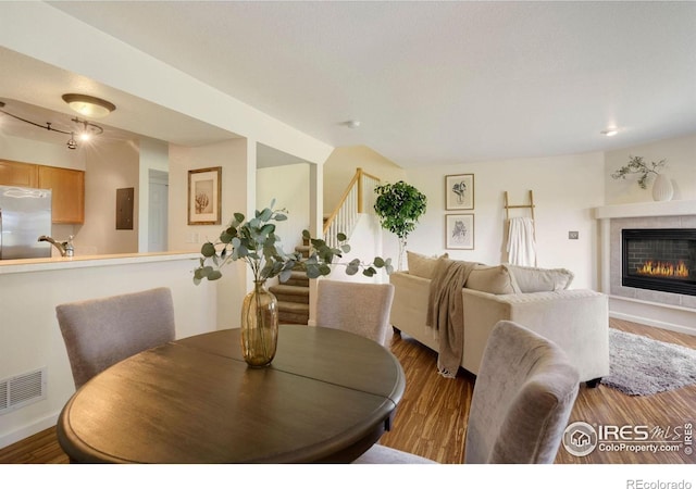 2120 Timber Creek Dr Unit H4, Fort Collins, CO 80528 - dining space featuring visible vents, wood finished floors, stairway, and a tile fireplace