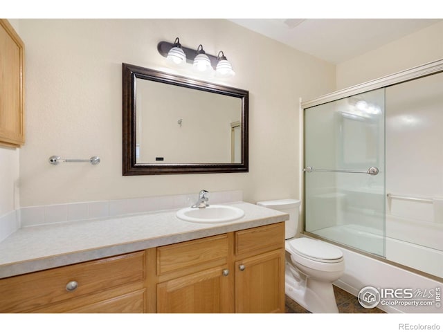 full bathroom featuring vanity, enclosed tub / shower combo, tile patterned floors, and toilet