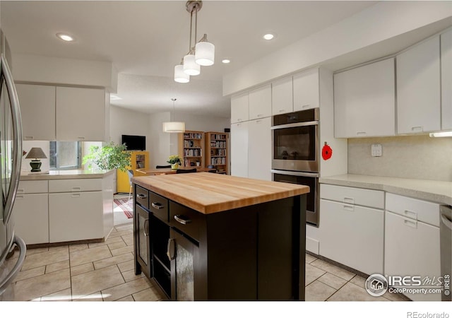 6611 Lakeview Dr, Boulder, CO 80303 - kitchen featuring light tile patterned flooring, appliances with stainless steel finishes, hanging light fixtures, butcher block countertops, and white cabinetry