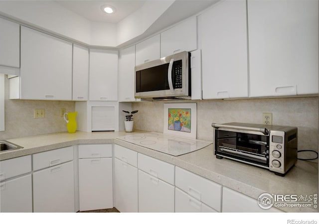 6611 Lakeview Dr, Boulder, CO 80303 - kitchen featuring white cabinets, stainless steel microwave, white electric stovetop, and light countertops
