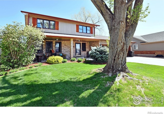 1021 Pinyon Dr, Windsor, CO 80550 - view of front of house with a porch, brick siding, and a front lawn