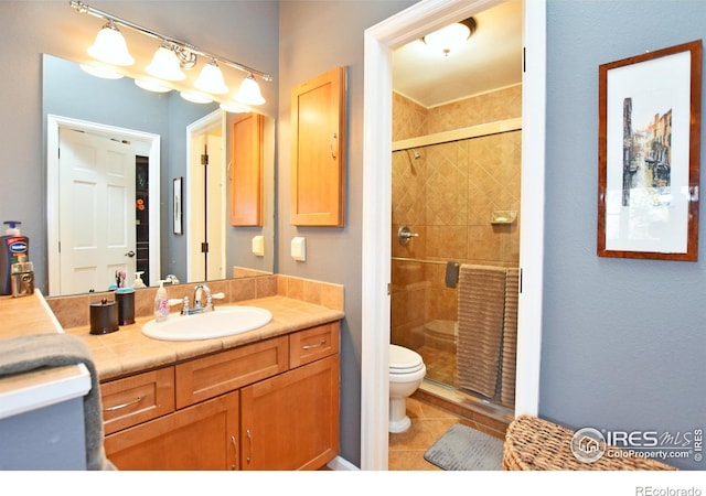 1021 Pinyon Dr, Windsor, CO 80550 - full bathroom featuring vanity, tile patterned flooring, a stall shower, and toilet