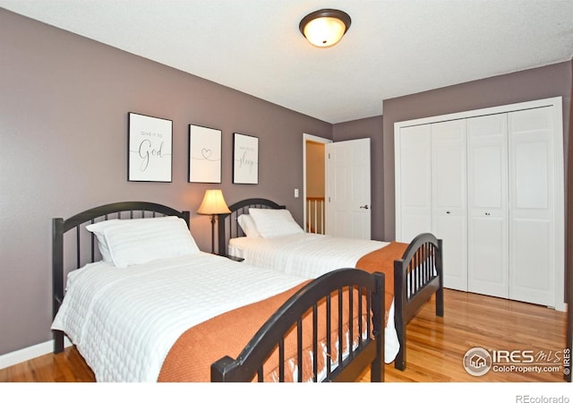 1021 Pinyon Dr, Windsor, CO 80550 - bedroom with a closet, light wood finished floors, and baseboards