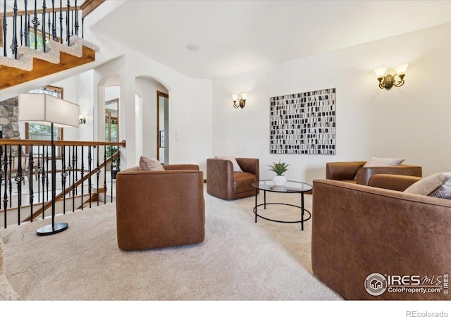 carpeted living area featuring arched walkways