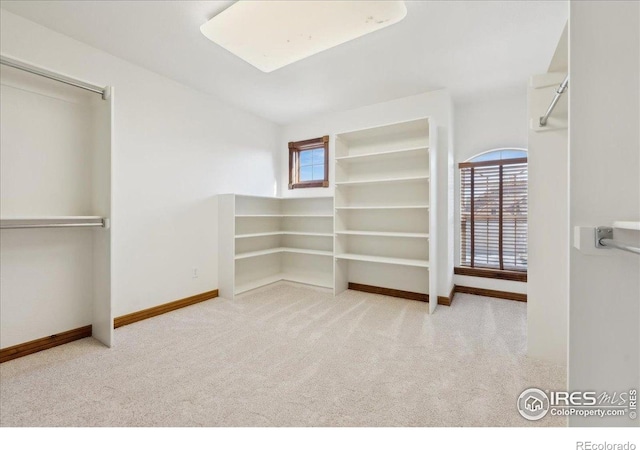 unfurnished bedroom with carpet floors, baseboards, and multiple windows