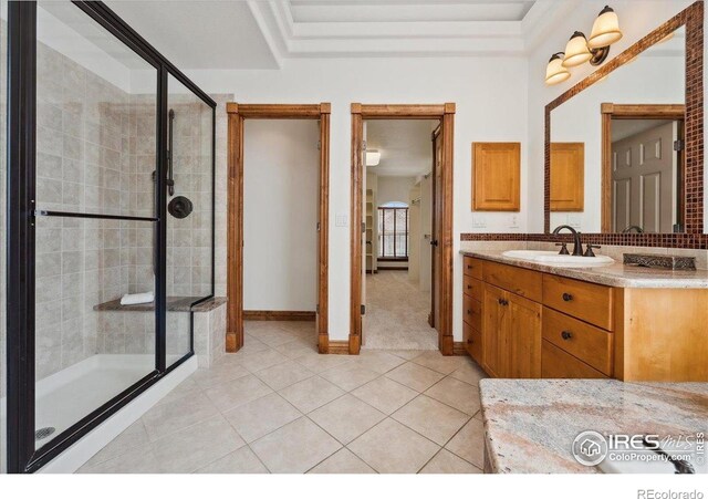 bathroom with baseboards, a shower stall, tile patterned flooring, and vanity