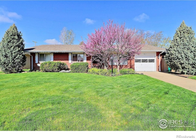 821 36th Ave, Greeley, CO 80634 - ranch-style house featuring brick siding, a garage, driveway, and a front lawn