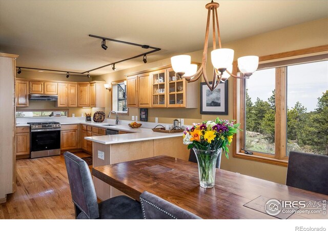 187 Rocky Knob Ln, Nederland, CO 80466 - kitchen featuring gas stove, light countertops, a sink, a notable chandelier, and glass insert cabinets