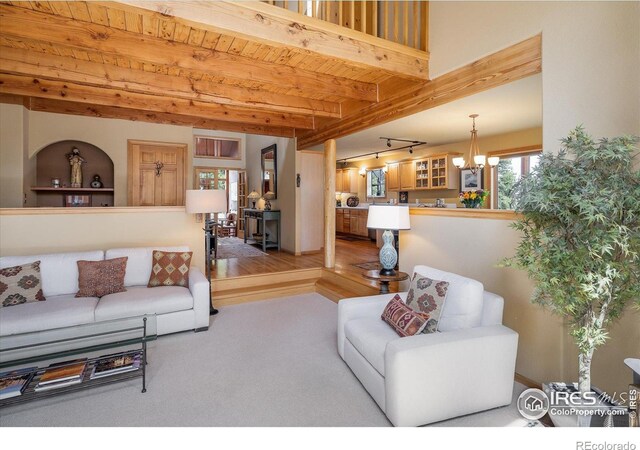 187 Rocky Knob Ln, Nederland, CO 80466 - living area featuring an inviting chandelier, wooden ceiling, beamed ceiling, and carpet flooring
