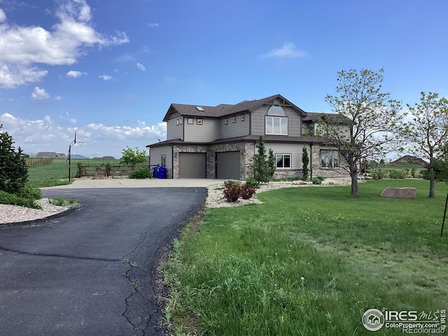 1105 Shelby Dr, Berthoud, CO 80513 - view of front facade featuring a garage, a front lawn, driveway, and stone siding