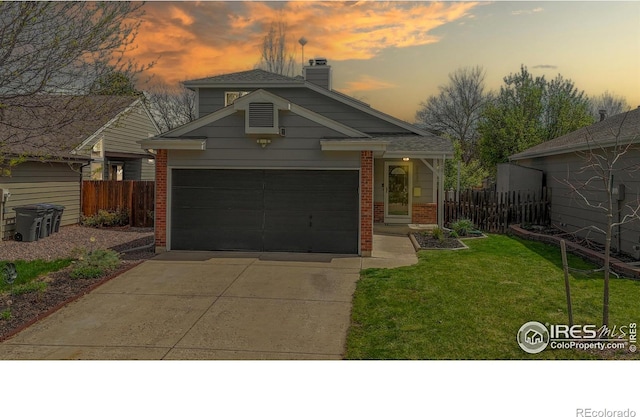 2330 Redwood Ave, Lafayette, CO 80026 - view of front of house featuring fence, a front lawn, brick siding, a chimney, and concrete driveway