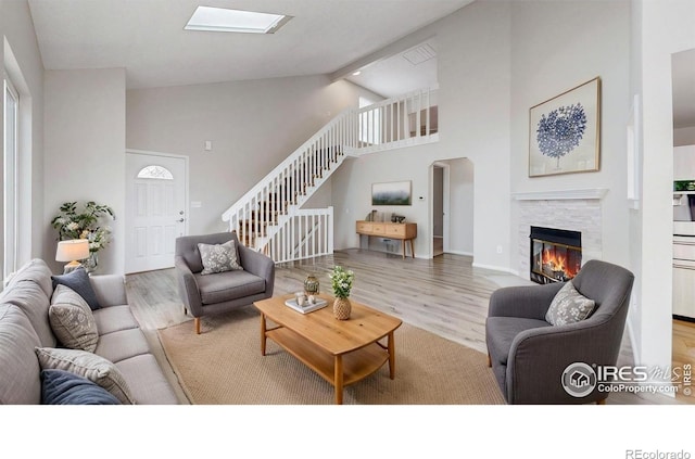 2330 Redwood Ave, Lafayette, CO 80026 - living room featuring stairway, high vaulted ceiling, a fireplace, and wood finished floors