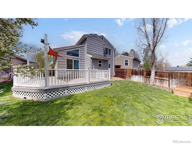 rear view of property featuring a fenced backyard, a yard, and a deck