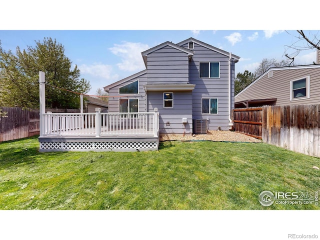 rear view of property with a fenced backyard, a wooden deck, and a yard