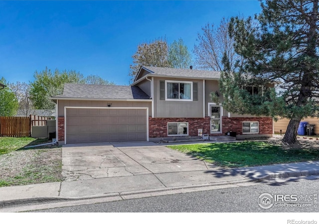 150 Lori Dr, Loveland, CO 80537 - raised ranch featuring fence, brick siding, a garage, a front yard, and driveway