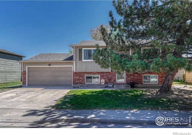 150 Lori Dr, Loveland, CO 80537 - view of front of home with an attached garage, a front yard, driveway, and brick siding