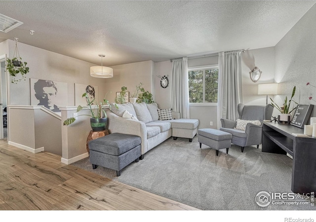 150 Lori Dr, Loveland, CO 80537 - living area featuring baseboards, visible vents, a textured ceiling, and wood finished floors