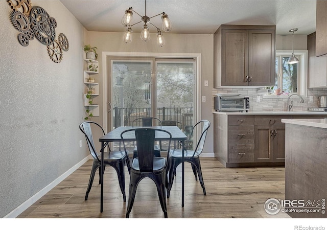150 Lori Dr, Loveland, CO 80537 - dining area featuring a textured wall, light wood-style floors, a textured ceiling, baseboards, and a toaster