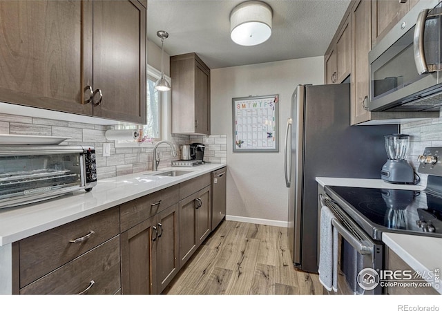 150 Lori Dr, Loveland, CO 80537 - kitchen with a sink, light wood-style flooring, decorative backsplash, and stainless steel appliances