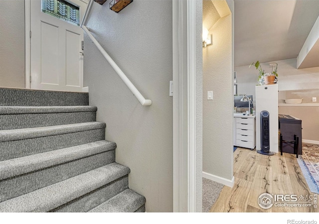 150 Lori Dr, Loveland, CO 80537 - stairs featuring baseboards, a textured wall, and wood finished floors