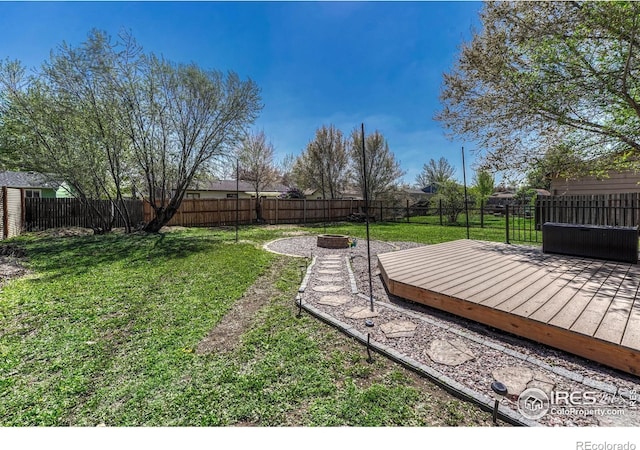 150 Lori Dr, Loveland, CO 80537 - view of yard featuring a fire pit, a wooden deck, and a fenced backyard
