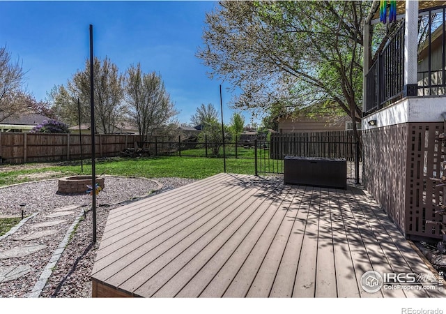 150 Lori Dr, Loveland, CO 80537 - wooden terrace with a fenced backyard, a lawn, and an outdoor fire pit
