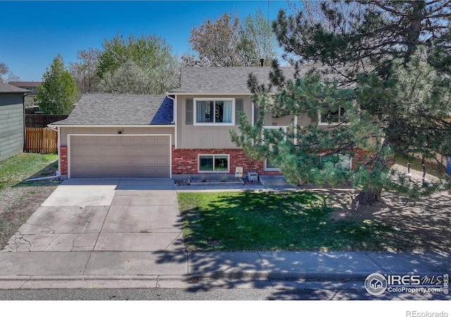 150 Lori Dr, Loveland, CO 80537 - view of front of house featuring fence, an attached garage, brick siding, a front yard, and concrete driveway