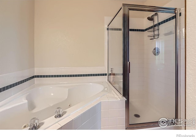 full bathroom featuring a stall shower and a whirlpool tub