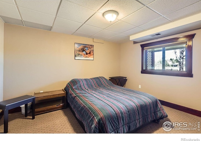 bedroom featuring carpet, visible vents, baseboards, and a paneled ceiling