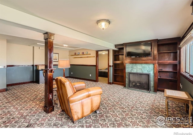 living room featuring a premium fireplace, baseboards, decorative columns, and carpet