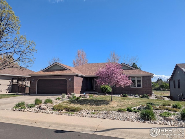 ranch-style home with a garage, a front lawn, brick siding, and driveway