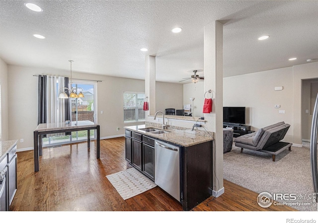 1693 Maseca Plaza Way, Severance, CO 80550 - kitchen featuring a sink, stainless steel dishwasher, open floor plan, wood finished floors, and ceiling fan