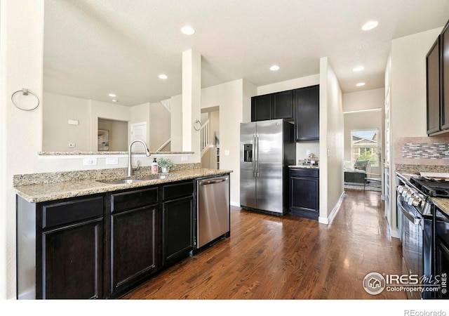 1693 Maseca Plaza Way, Severance, CO 80550 - kitchen with appliances with stainless steel finishes, a sink, dark wood-style flooring, dark cabinets, and recessed lighting