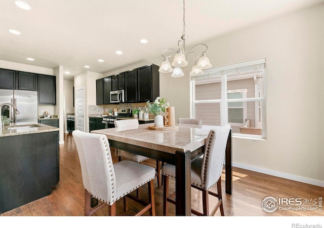 1693 Maseca Plaza Way, Severance, CO 80550 - dining area with a chandelier, light wood finished floors, baseboards, and recessed lighting