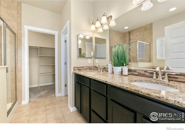 1693 Maseca Plaza Way, Severance, CO 80550 - full bath with a stall shower, double vanity, a walk in closet, and tile patterned floors