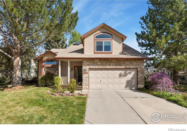view of front facade with an attached garage, driveway, a front yard, and stone siding