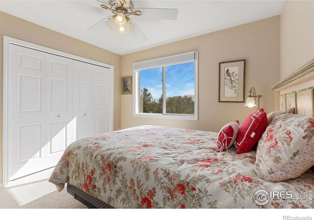 carpeted bedroom featuring ceiling fan and a closet