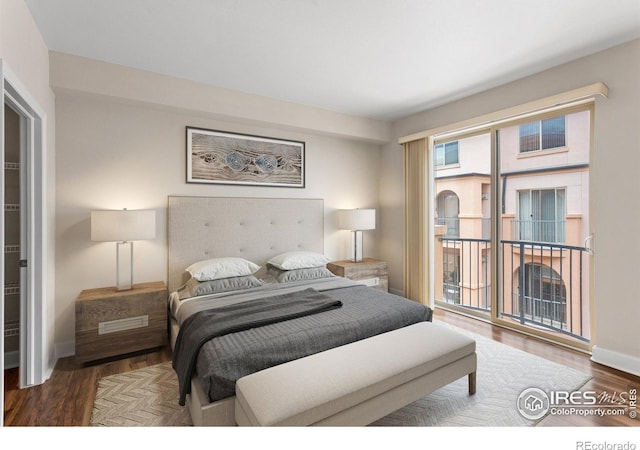 bedroom featuring baseboards, access to outside, and wood finished floors