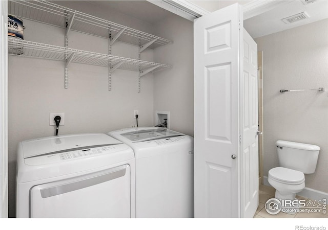 clothes washing area with independent washer and dryer, laundry area, tile patterned flooring, baseboards, and visible vents