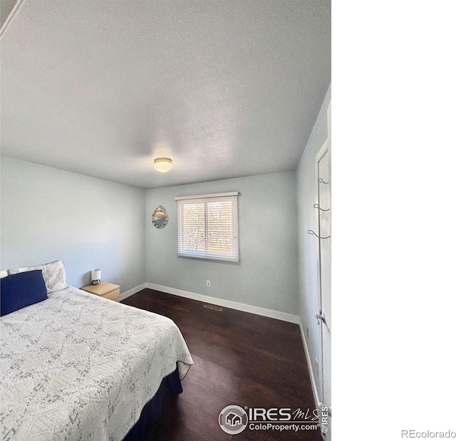 1600 Dogwood Ct, Fort Collins, CO 80525 - bedroom featuring baseboards, dark wood finished floors, a textured ceiling, and visible vents
