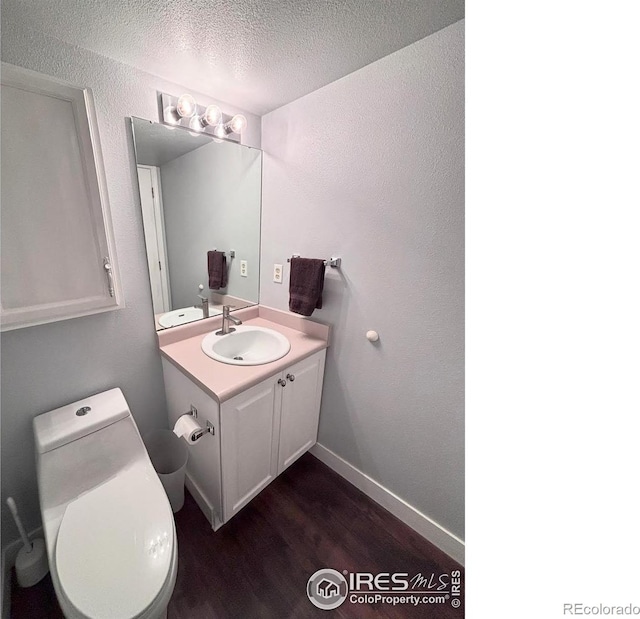 1600 Dogwood Ct, Fort Collins, CO 80525 - half bathroom featuring vanity, wood finished floors, toilet, baseboards, and a textured ceiling