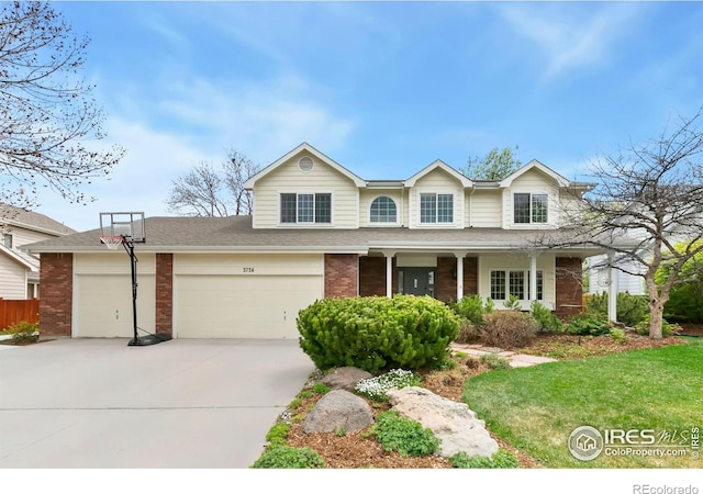 traditional-style home with brick siding, a front lawn, a porch, and concrete driveway