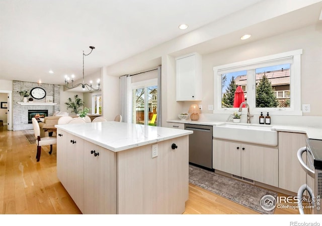 kitchen featuring a kitchen island, appliances with stainless steel finishes, a wealth of natural light, and a sink